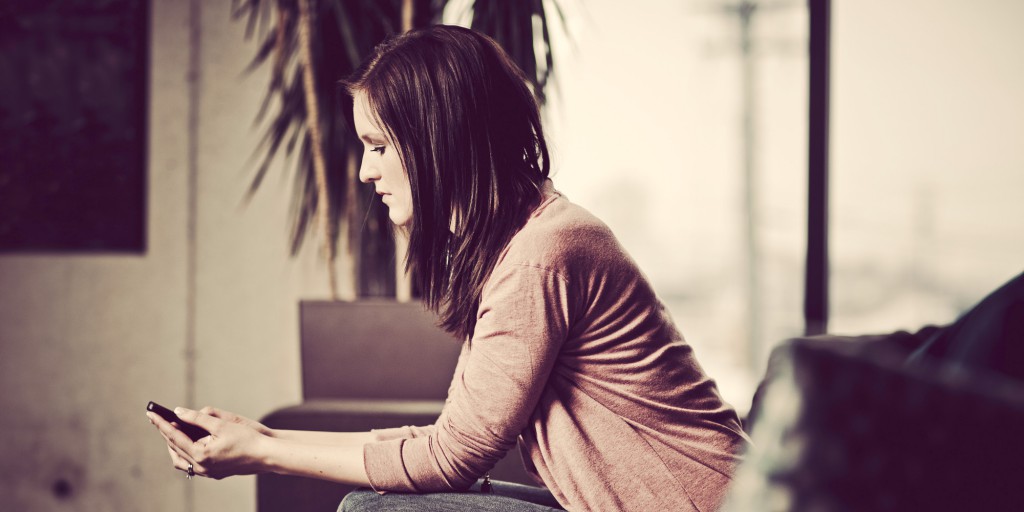 sad girl with cell phone spy app