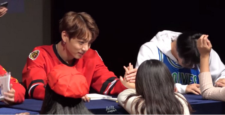 bts jungkook holding a fan s hand during the group s fansign event