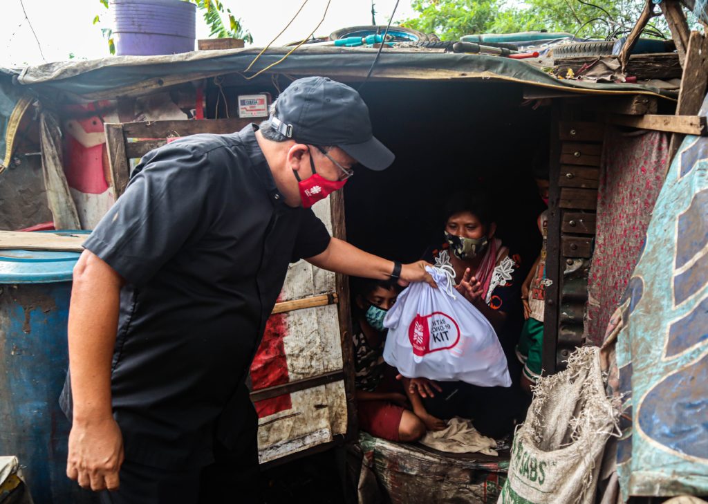 Caritas Manila Executive Director Fr. Anton CT Pascual distributing aid