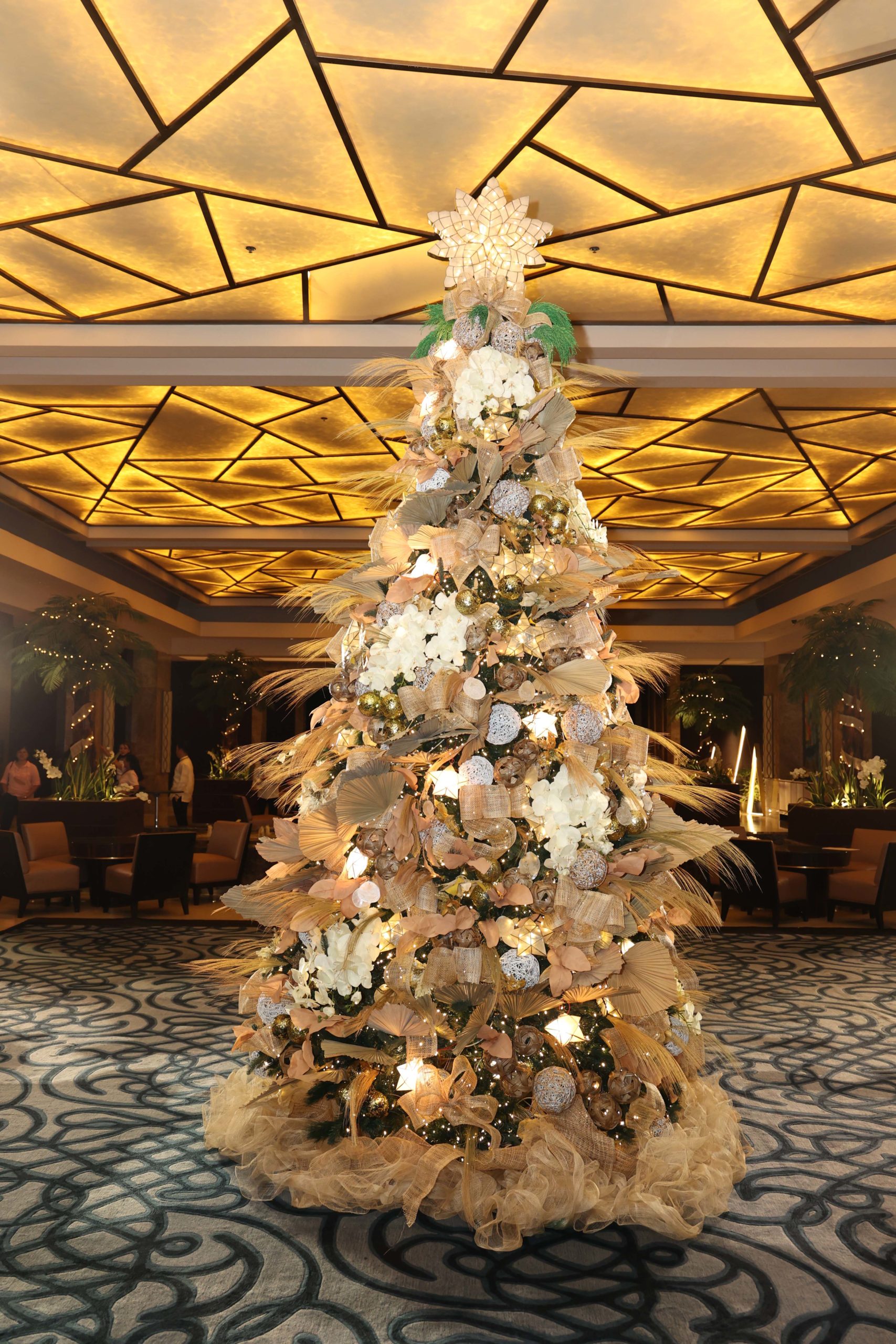 Christmas tree festooned with sinamay streamers capiz shell ornaments and woven miniatures became the scenic centerpiece at the main lobby of Crimson scaled